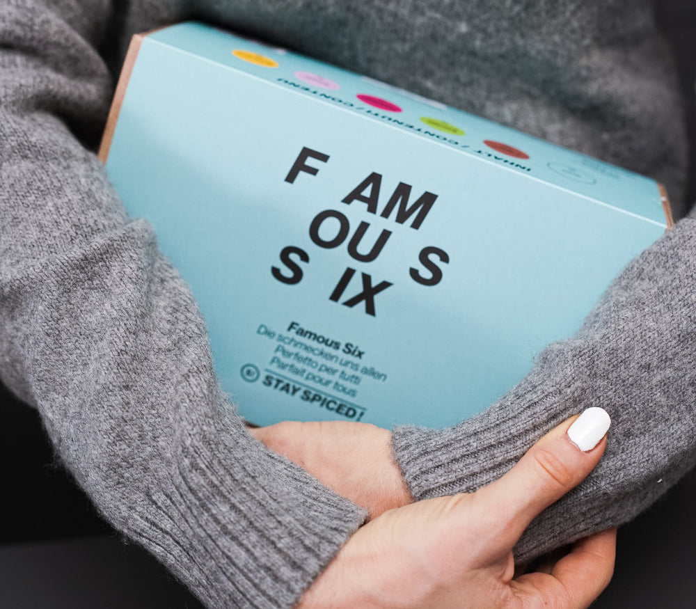 Eine Person hält die hellblaue Famous Six Gewürz-Geschenkbox in den Händen, gefüllt mit sechs beliebten Gewürzmischungen