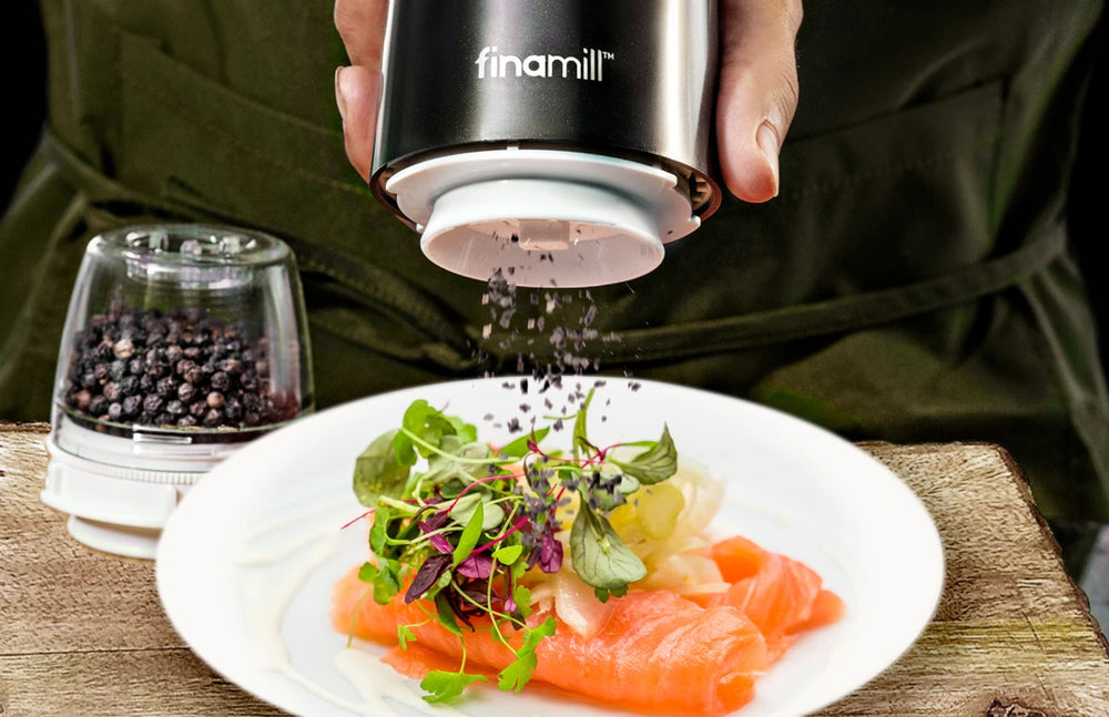 Eine elektrische FinaMill Gewürzmühle im Einsatz beim Kochen, um frische Gewürze für maximales Aroma zu mahlen