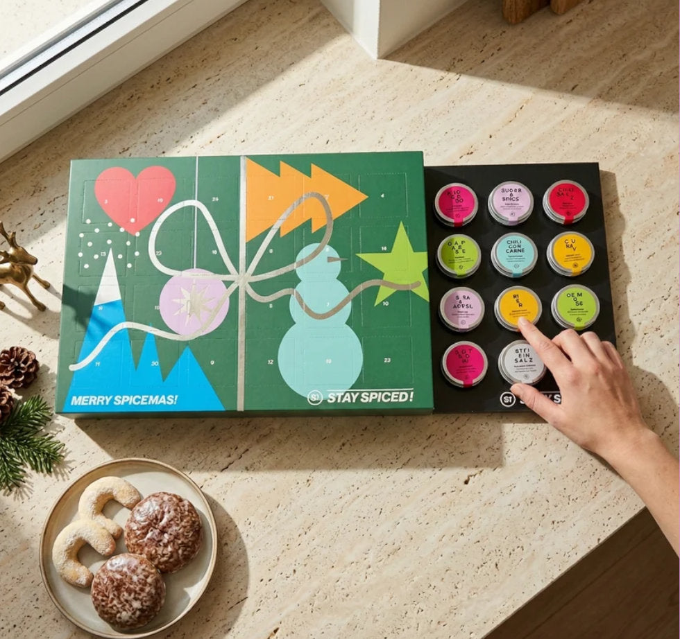 STAY SPICED ! Gewürz Adventskalender in einer modernen Küche, bei dem eine Person eine Schraubdose entnimmt