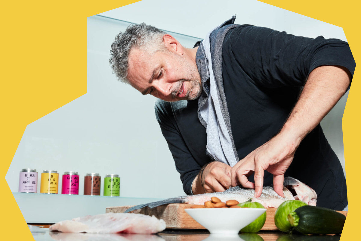 Ein Profikoch beim Zubereiten von frischem Fisch, umgeben von hochwertigen Premium-Gewürzen für die Gastronomie
