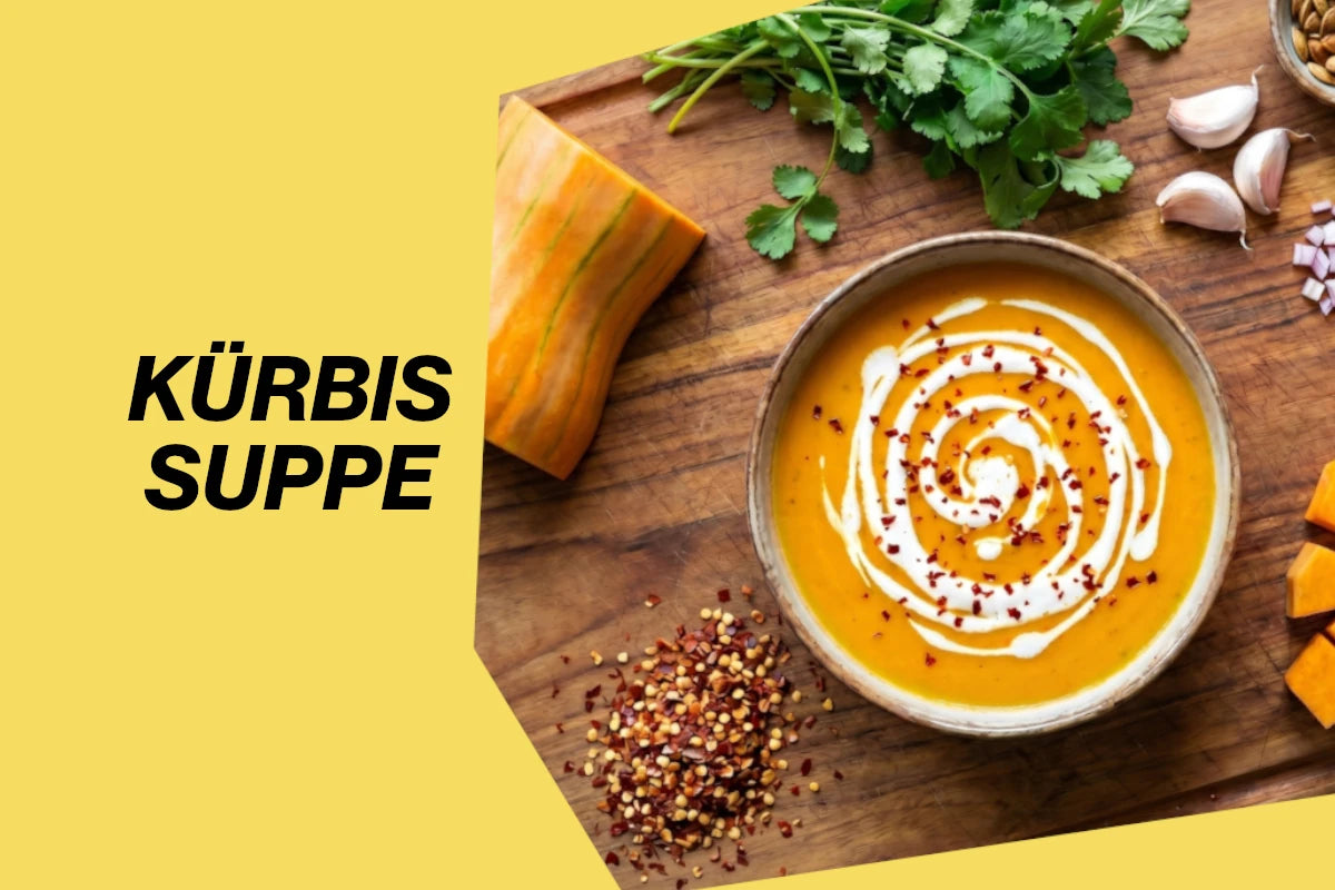 Eine Schüssel mit cremiger Kürbissuppe, verfeinert mit exotischen Gewürzen, auf einem Holztisch