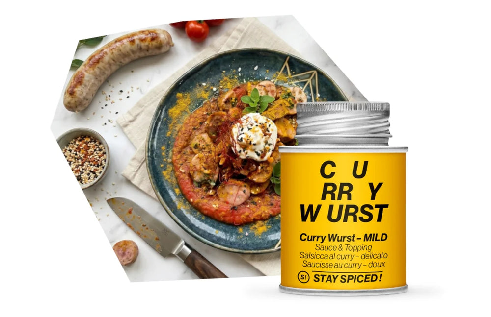 Ein rustikal angerichteter Teller mit geschnittener Currywurst und Currysauce, flankiert von einer Grillwurst und einer STAY SPICED ! Currywurst-Gewürzdose