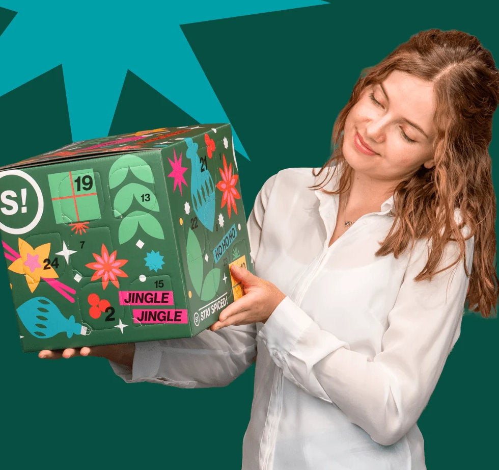 Frau hält den grünen STAY SPICED! Gewürz Adventskalender Pure in den Händen