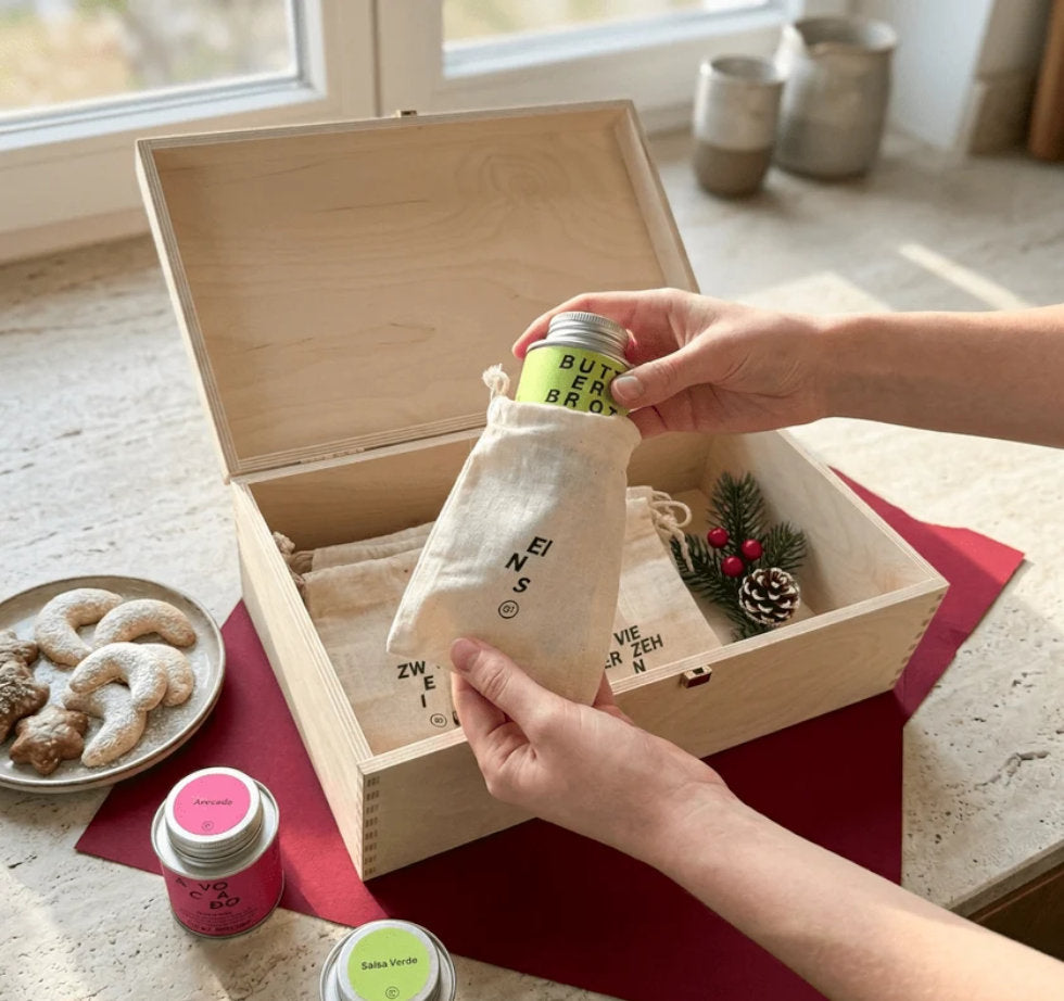 Die STAY SPICED! DIY Adventskalender Holzbox dekoriert mit nummerierten Jutesaeckchen und einem Teller mit traditionellem Weihnachtsgebaeck