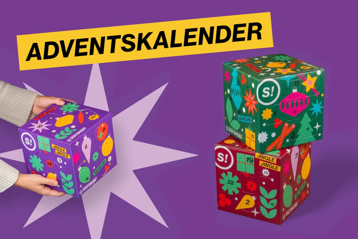 Drei farbige STAY SPICED! Gewürz-Adventskalender 2026 vor violettem Hintergrund