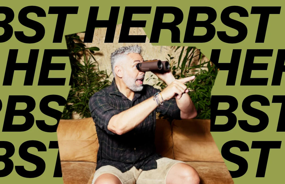 Ein Mann blickt humorvoll durch ein Fernglas, eingerahmt von markanten Herbst-Schriftzügen, passend zum Thema wärmende Wohlfühlgerichte